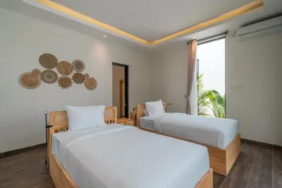two beds in a room with a window at Villa Selikur 2 - Brand New! Spacious 3BR Villa in Seminyak in Seminyak