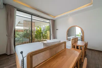 a bedroom with two beds and a table and a mirror at Villa Selikur 2 - Brand New! Spacious 3BR Villa in Seminyak in Seminyak