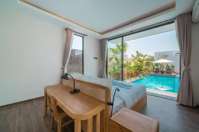 a bedroom with a bed and a table and a pool at Villa Selikur 2 - Brand New! Spacious 3BR Villa in Seminyak in Seminyak