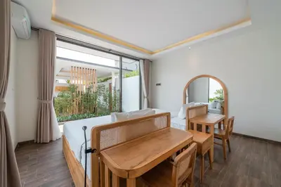 a bedroom with a bed and a table and a mirror at Villa Selikur 2 - Brand New! Spacious 3BR Villa in Seminyak in Seminyak