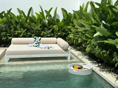 a couch sitting next to a pool of water at Villa Solaris Umalas by Santi Management in Kerobokan