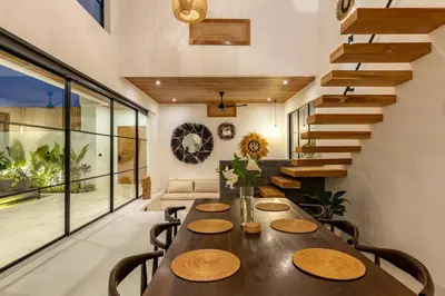 a dining room with a table and a staircase at Villa Anita Umalas by Santi Management in Kerobokan