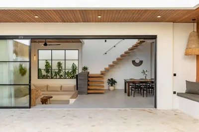 a living room with a staircase and a table at Villa Anita Umalas by Santi Management in Kerobokan
