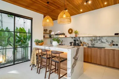 a kitchen with a bar with stools at Villa Anita Umalas by Santi Management in Kerobokan