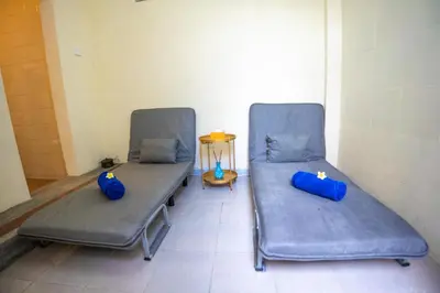 two hospital beds with blue pillows in a room at BS Home in Kuta