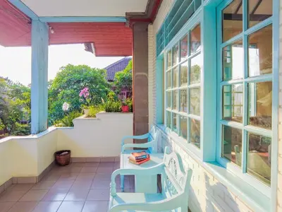a porch with two chairs and two windows at BS Home in Kuta