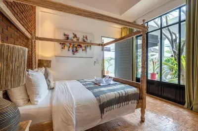 a bedroom with a bed and a large window at Villa Vaiana Seminyak in Seminyak