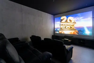 a cinema room with a large screen with a movie at Villa KALOOKA, a vacation in paradise. in Seminyak