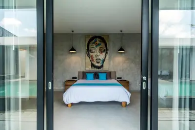 a bedroom with a bed with a face on the wall at Villa KALOOKA, a vacation in paradise. in Seminyak