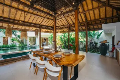 a dining room with a wooden table and chairs at Villa Marula at Bidadari in Seminyak