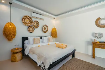 a bedroom with a bed and plates on the wall at Villa Marula at Bidadari in Seminyak