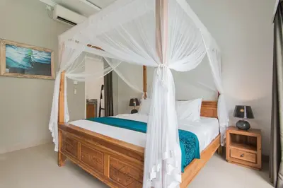a bedroom with a bed with a canopy at Stylish Three Bedroom Villa Near Atlas Beach Club & Beach. in Canggu