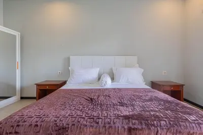 a bedroom with a large bed with two night stands at Villa Rose 1 Sanur in Sanur