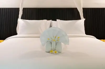 a stuffed elephant sitting on top of a bed at The Gardens Seminyak in Seminyak