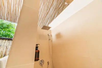 a shower in a bathroom with a ceiling at The Gardens Seminyak in Seminyak