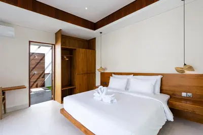 a bedroom with a white bed and a window at J4 Villas Sanur in Sanur