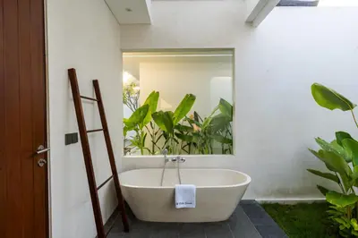 a bathroom with a large mirror and a bath tub at J4 Villas Sanur in Sanur