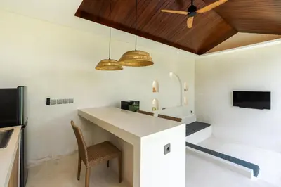 a kitchen with a counter and a table and chairs at J4 Villas Sanur in Sanur