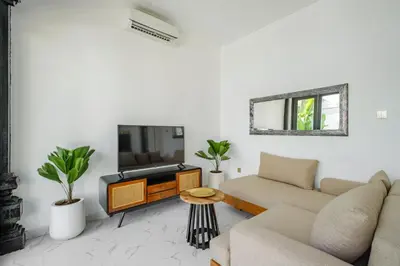 a living room with a couch and a tv at Villa Marina Seminyak in Seminyak