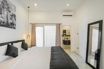 a bedroom with a large bed and a mirror at Villa Marina Seminyak in Seminyak