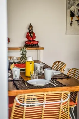 a dining room table with chairs and a table with at Villa Mana Tea 2 bedrooms & pool Seminyak in Seminyak