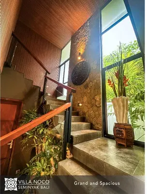 a staircase in a house with a large window at Noco Luxury Villa Seminyak in Seminyak