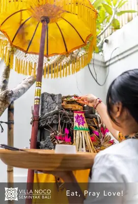 a woman working on a stand with an umbrella at Noco Luxury Villa Seminyak in Seminyak
