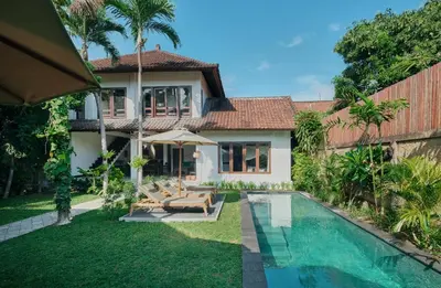 a villa with a swimming pool and a house at Nativ Living Villa Legian 6BR Villa 16px Big Group Walk to 66 Beach in Seminyak