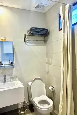 a bathroom with a toilet and a sink at Charlie Guest House in Nusa Dua