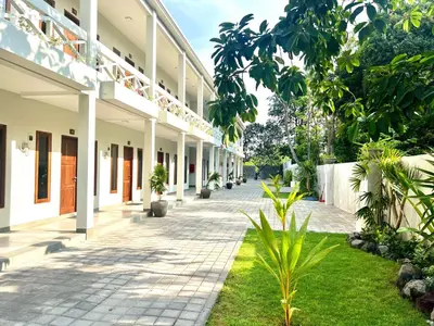 an empty courtyard of a building with plants at Charlie Guest House in Nusa Dua