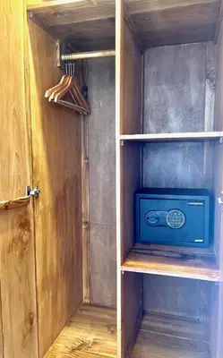 a closet with a cupboard with a microwave in it at Charlie Guest House in Nusa Dua