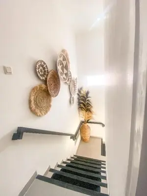 a staircase with baskets and a plant on the wall at Villa Coco Legian in Legian