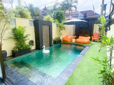 a pool in a backyard with a swan in the water at Villa Coco Legian in Legian