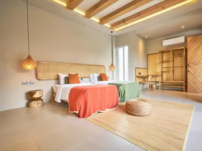a bedroom with a large bed and a rug at Luna Ola Villa Berawa in Canggu