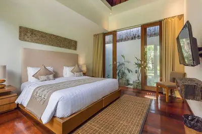 a bedroom with a large bed and a large window at Eshara 3 our Peaceful 3BR Pool Villa close to Oberoi Beach in Seminyak