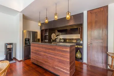 a kitchen with a large wooden bar in a room at Eshara 21 our Luxury 5BR Villa Escape and huge pool Oberoi Beach in Seminyak