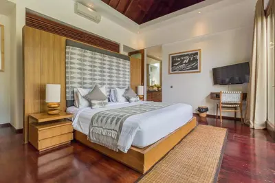 a bedroom with a large bed and a television at Eshara 21 our Luxury 5BR Villa Escape and huge pool Oberoi Beach in Seminyak