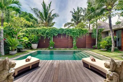 a backyard with a swimming pool and a wooden deck at Eshara 23 an Amazing 5 BR Pool Villa walking distance to Beach in Seminyak