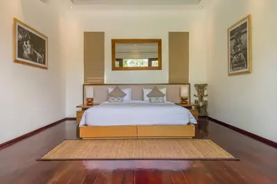 a bedroom with a bed and a mirror on the wall at Eshara 23 an Amazing 5 BR Pool Villa walking distance to Beach in Seminyak