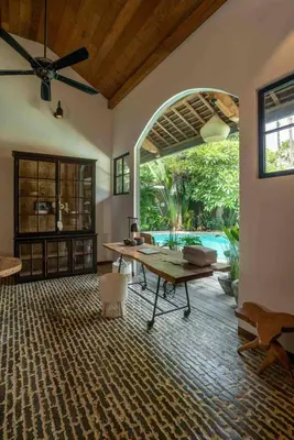 a living room with a table and a pool at Villa Lio - Tropical Escape in Canggu in Canggu