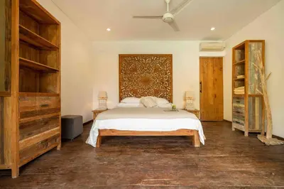 a bedroom with a bed and a wooden wall at Villa Lio - Tropical Escape in Canggu in Canggu