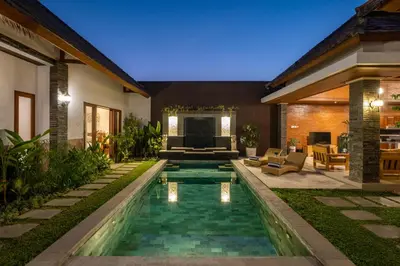 a backyard with a swimming pool and a house at Villa Lapiz in Seminyak