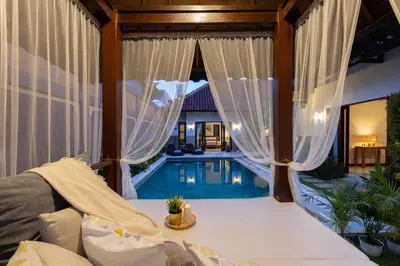 a living room with a pool and curtains and a couch at Villa Lapiz in Seminyak