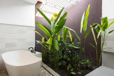 a bathroom with a bath tub and some plants at Villa Lapiz in Seminyak
