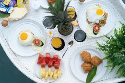 a white table topped with plates of breakfast foods at Villa Lapiz in Seminyak
