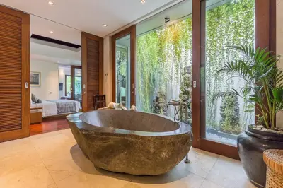 a large bathroom with a large tub in front of windows at Eshara 123 in Oberoi our 8 BR Villa with 3 Pool close to Beach in Seminyak