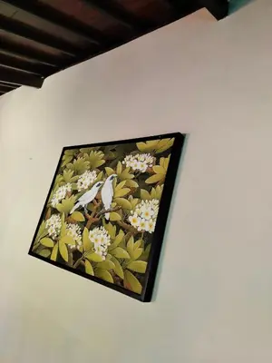 a painting of flowers on a wall at Villa Layang Bulan a homey guesthouse for men near the beach in North Kuta in Denpasar