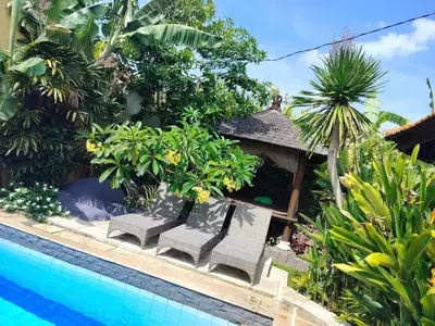 a resort with a swimming pool and some plants at Villa Layang Bulan a homey guesthouse for men near the beach in North Kuta in Denpasar