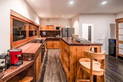 a kitchen with wooden cabinets and a counter at Jado 1 Unique Cinema Entertainment Villa in Umalas in Kerobokan
