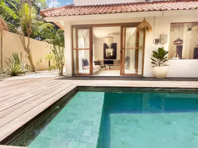 a swimming pool in front of a house at Stylish 2bdr poolvilla Centre Seminyak in Seminyak